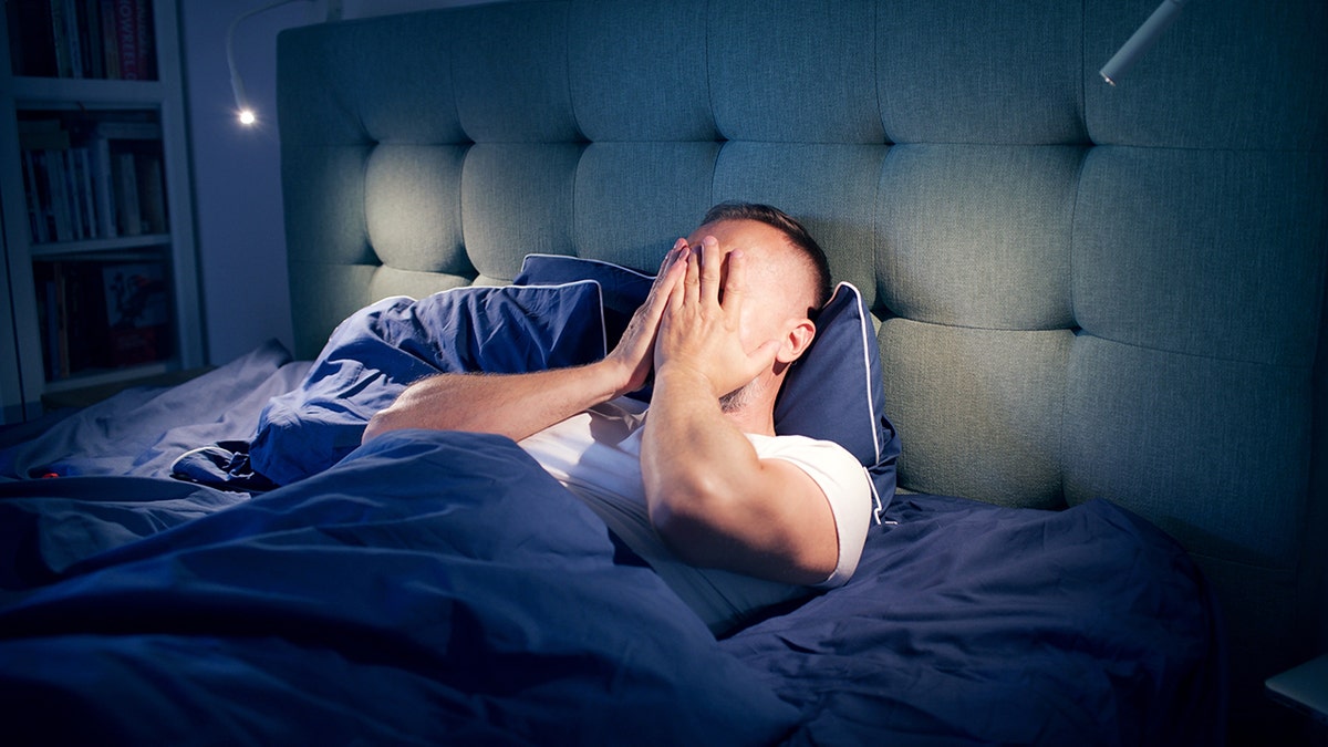 frustrated man awake in bed