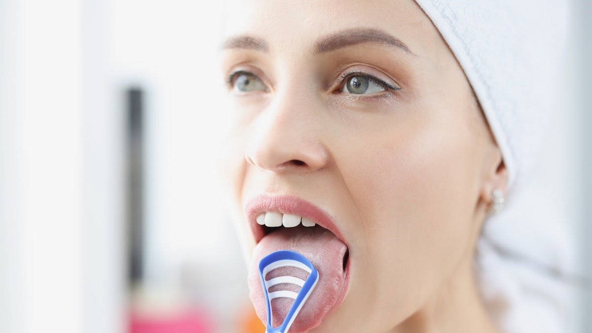 Woman using tongue-scraper