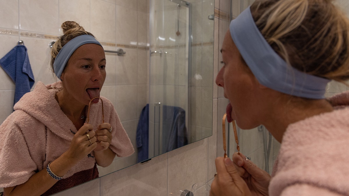 Person scraping their tongue