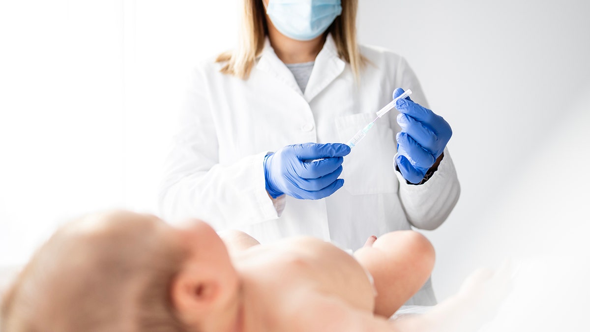 Pediatric doctor preparing vaccine injection for baby