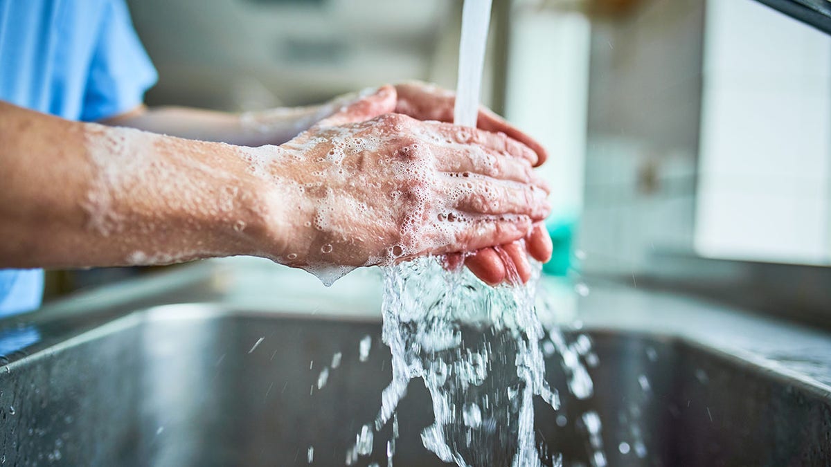 Nurse washing hands with soap to avoid covid 19
