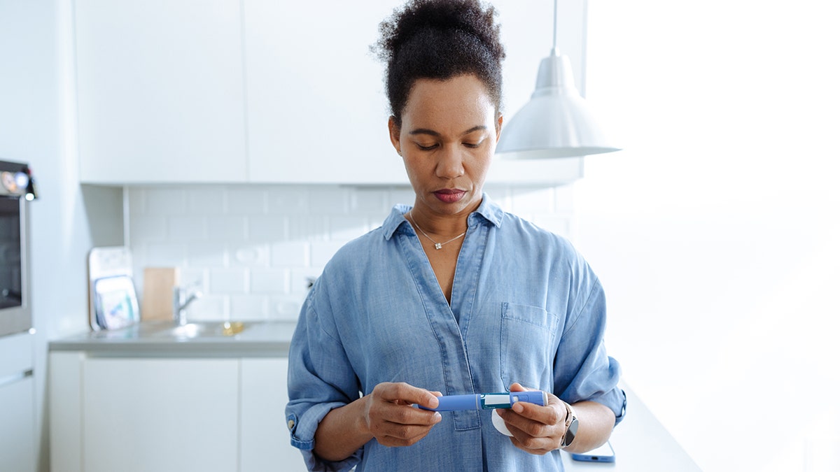 A woman prepares to administer an insulin injection