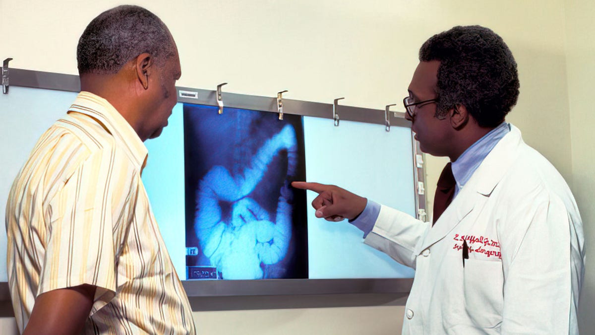 A doctor goes over a patient's x-ray, screening for colon cancer.