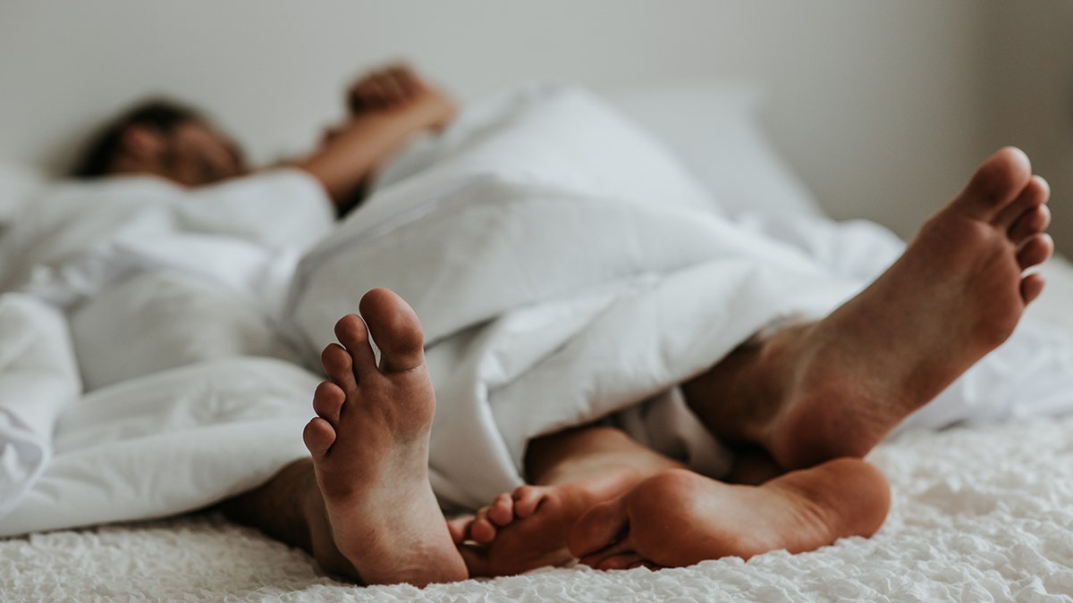 couple's feet at the end of the bed
