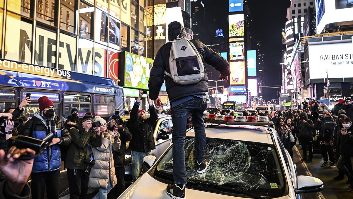 man smashing windshield of police car in Times Square in January 2023