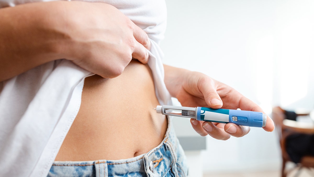 woman injecting weight loss drug in stomach