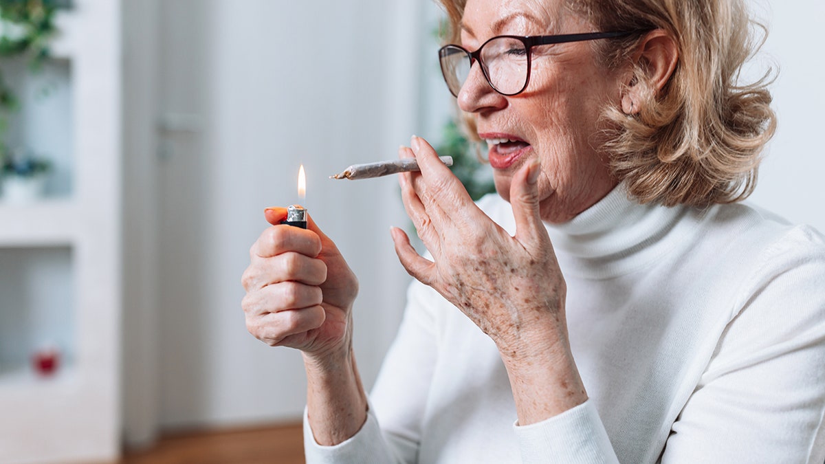 older woman lights up marijuana joint