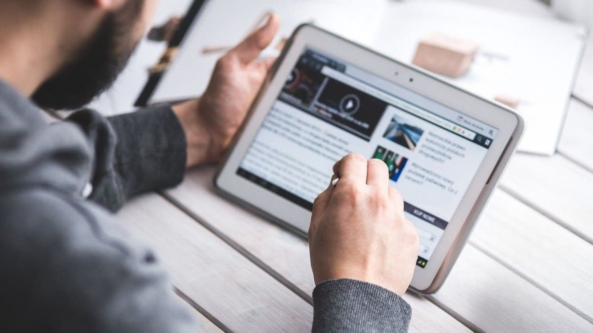 A man reading an article on his tablet.