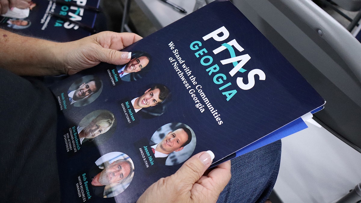 Woman holds PFAS informational folder in GA