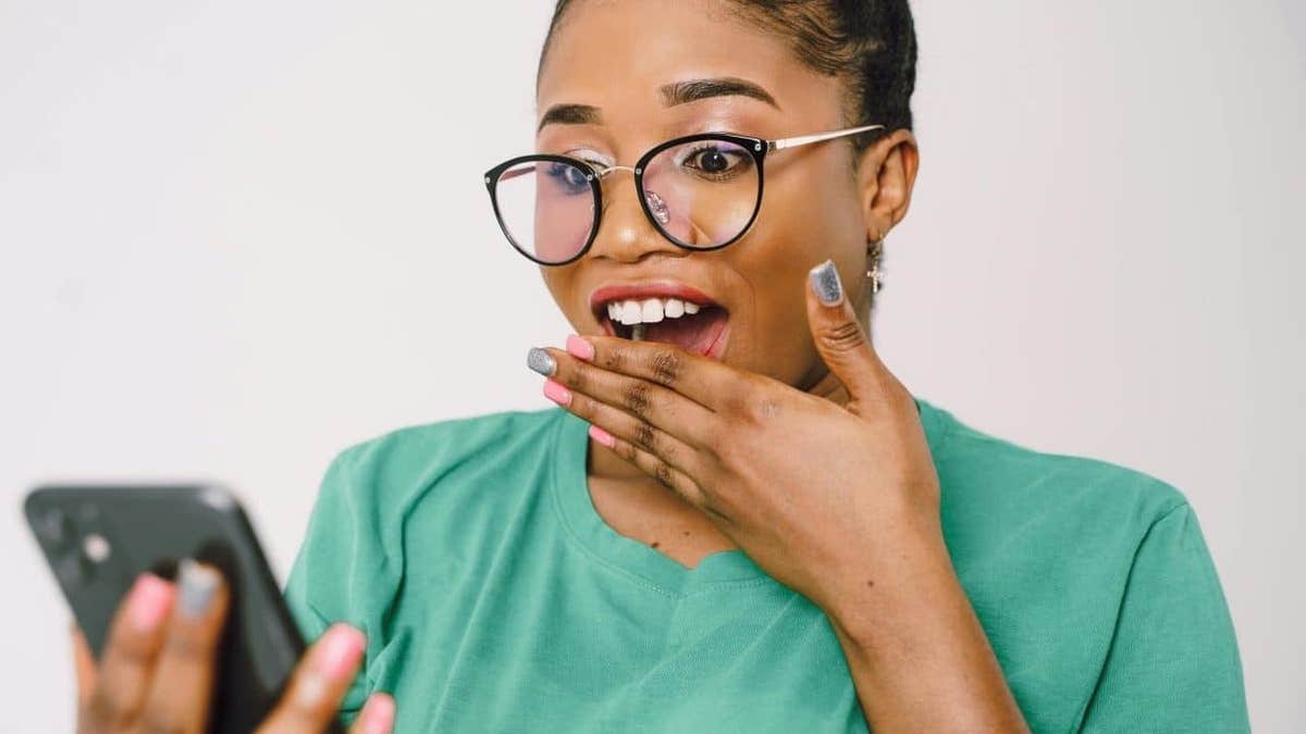 A woman looking surprised at her Android phone’s screen.