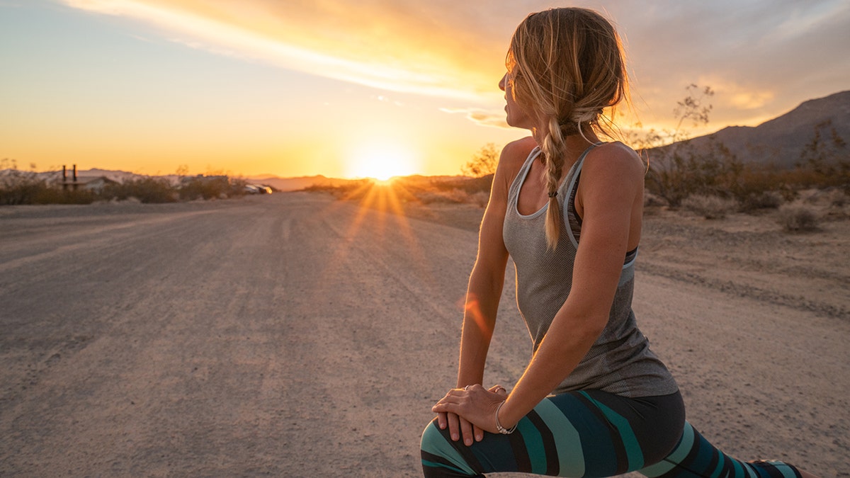 woman stretching at sunrise outside