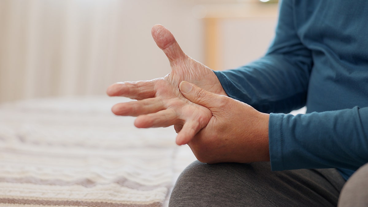 Man with Parkinson's disease holds his own hand