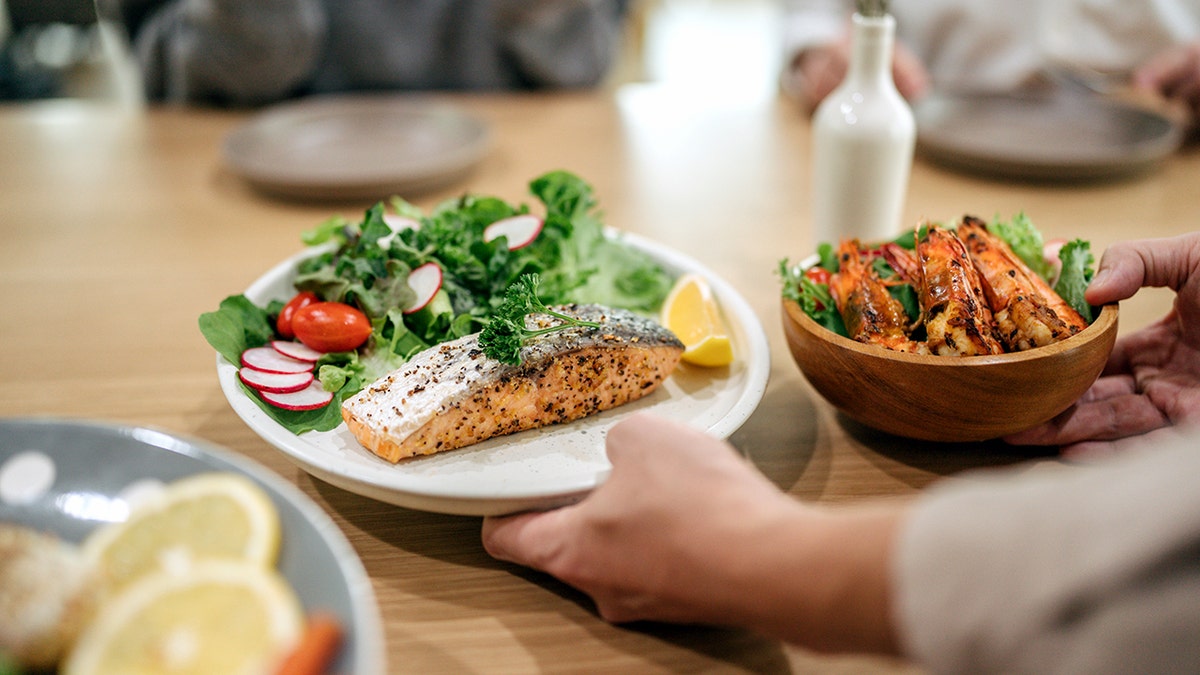 Person eating seafood and other whole foods