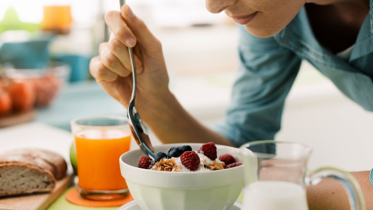 Woman eating yogurt with fruit
