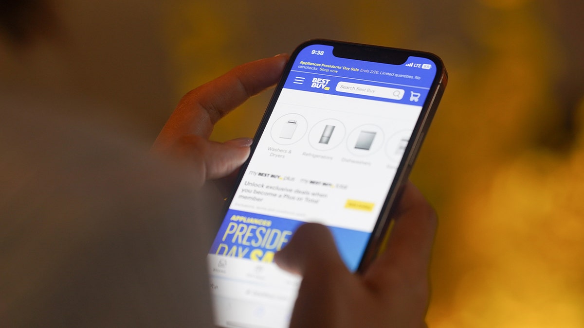 person shopping online through best buy phone app