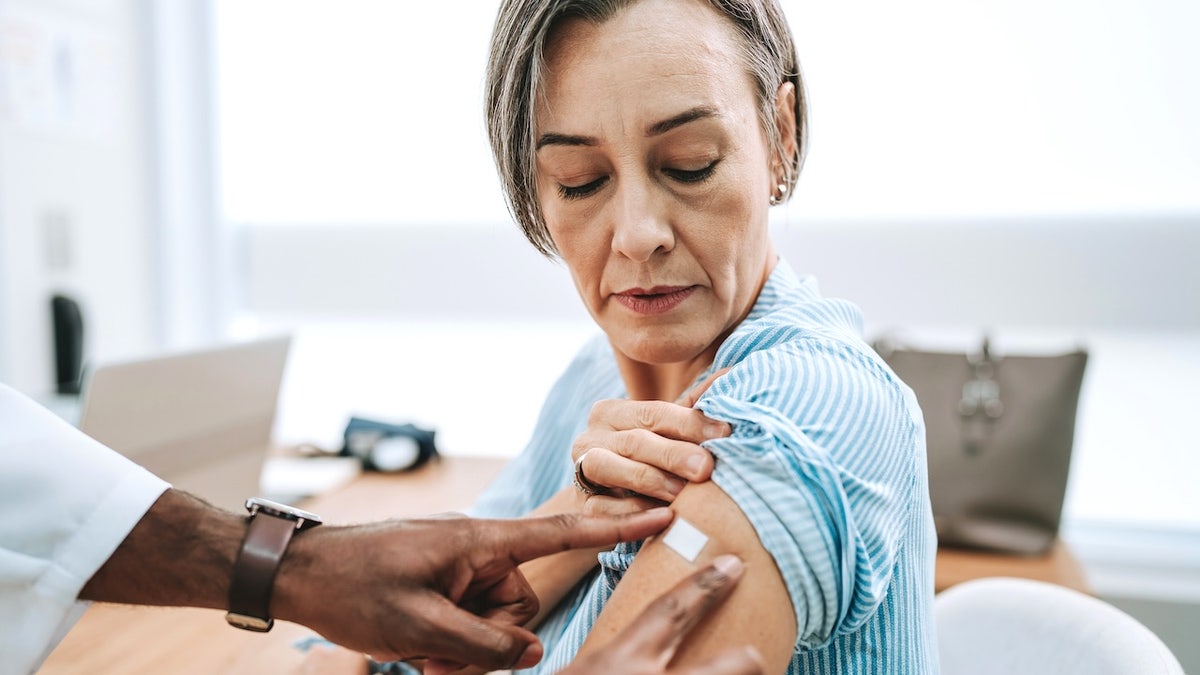 Older woman bandage after vaccine