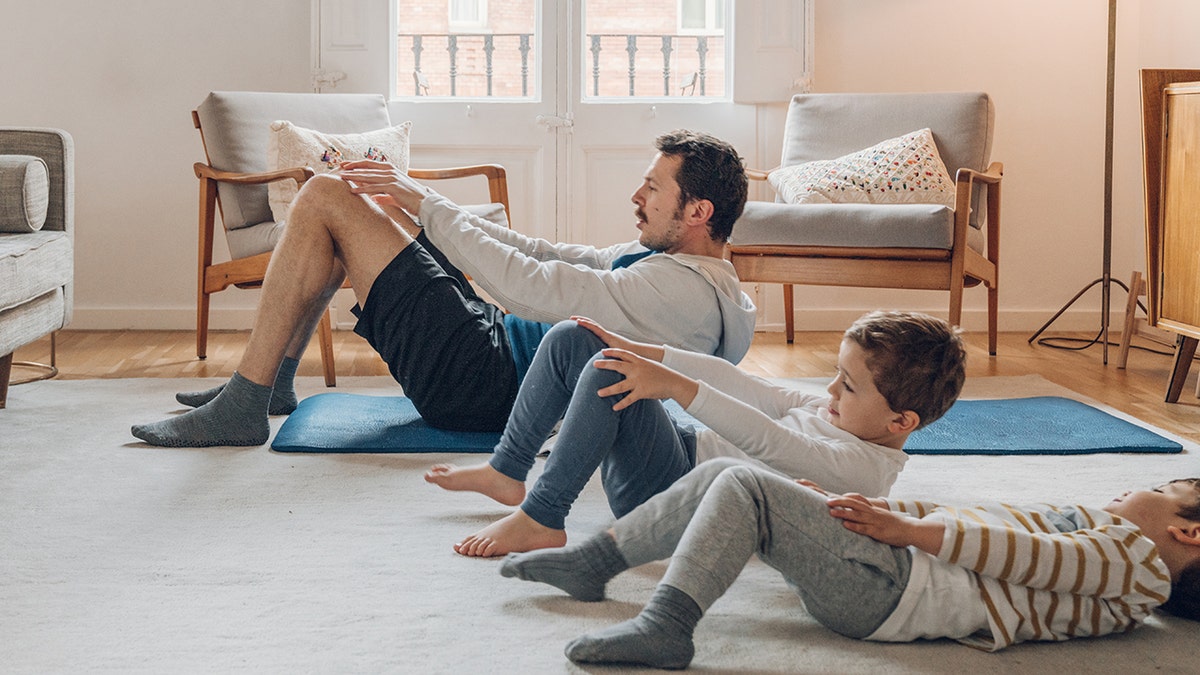 Father with children exercising at home