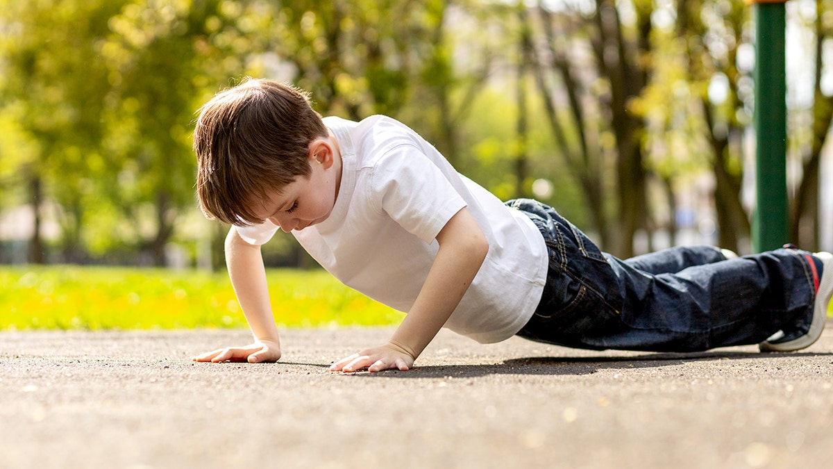 boy doing pushups on the playground