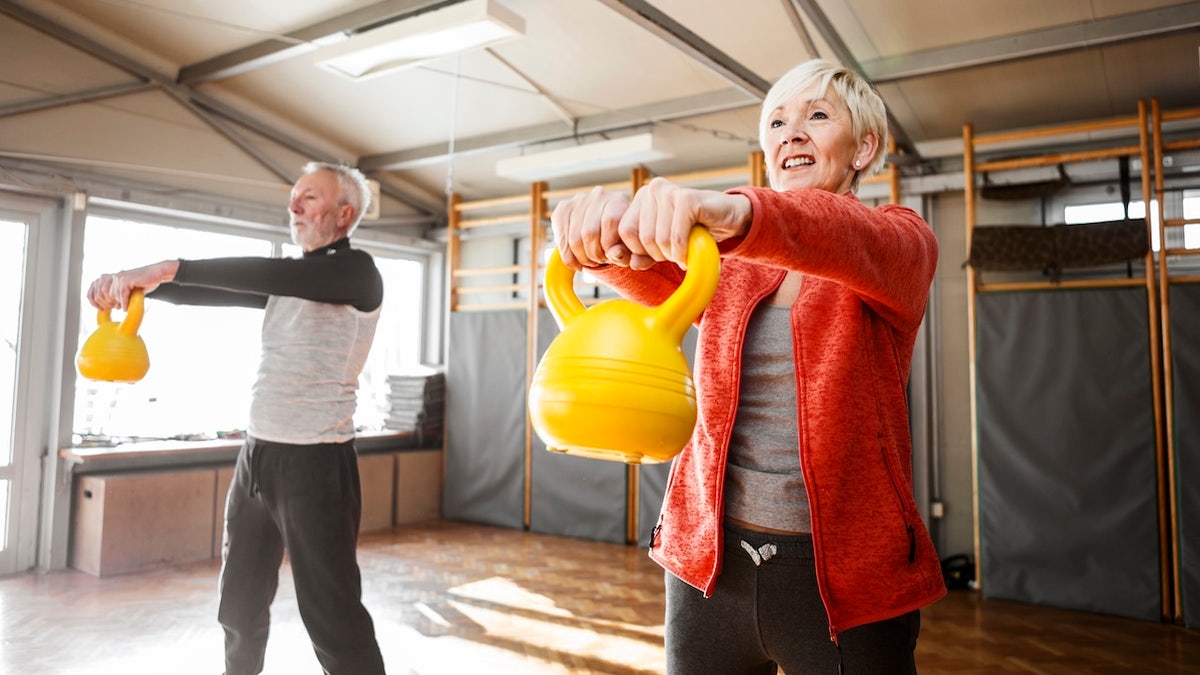 Older couple lifting kettlebells