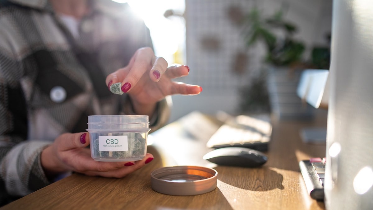 Woman taking CBD gummies