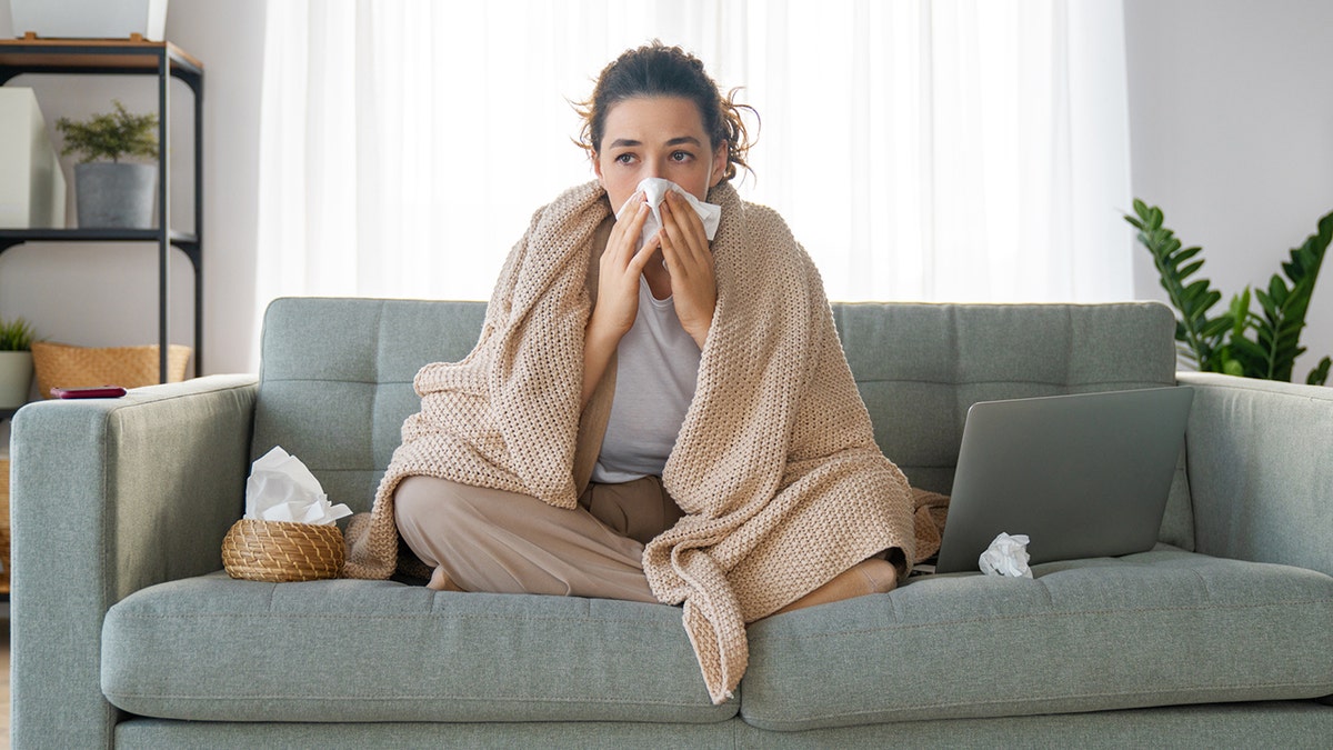 woman blows nose into tissue