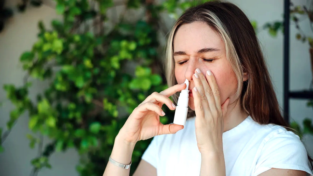 Woman using nasal spray
