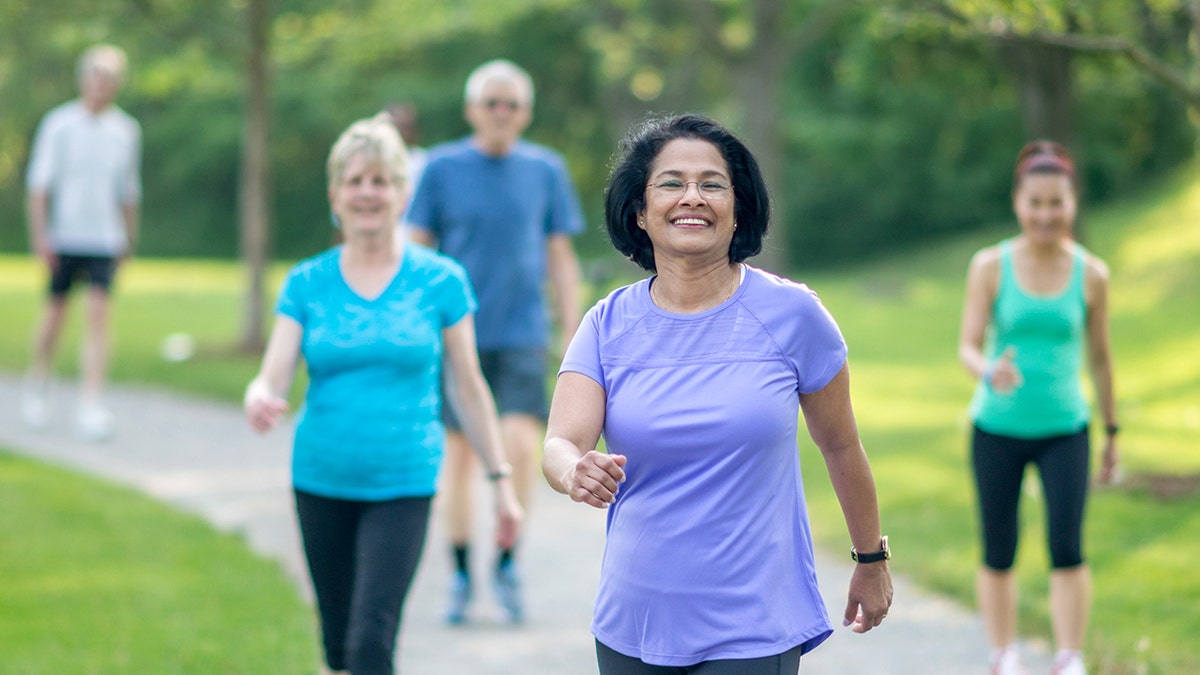 Group of seniors walking together outside and smiling.