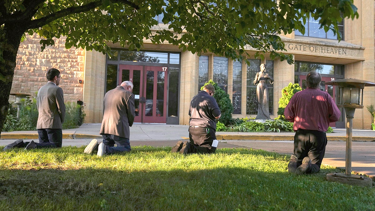 Mourners visit a memorial set up for victims of the mass school shooting at a Catholic school church.
