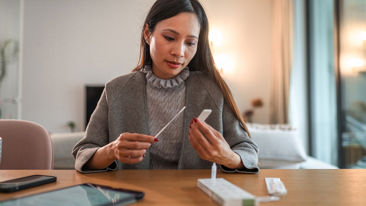 woman takes at-home rapid test