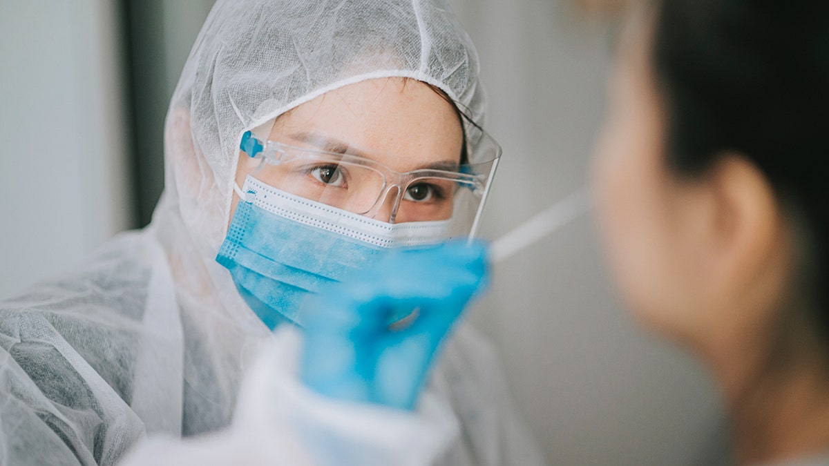 doctor tests patient with nasal swab