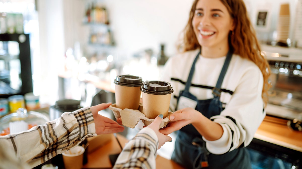 girl giving take away coffee cups to a customer