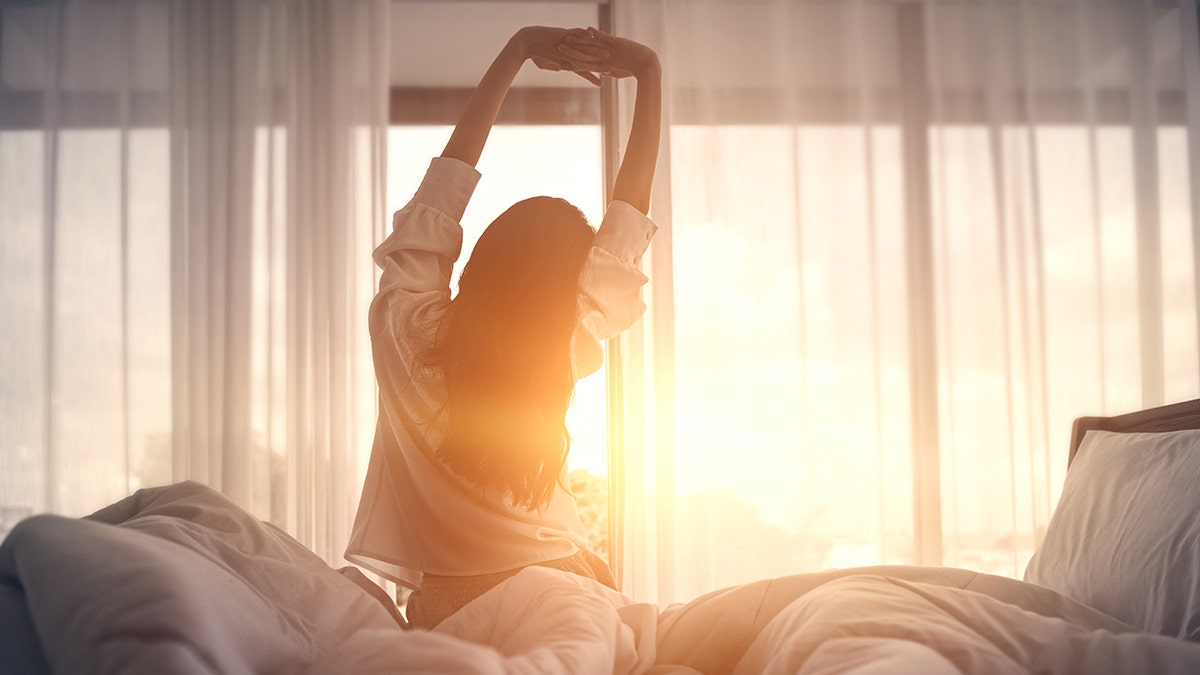 A woman stretching in the morning sun