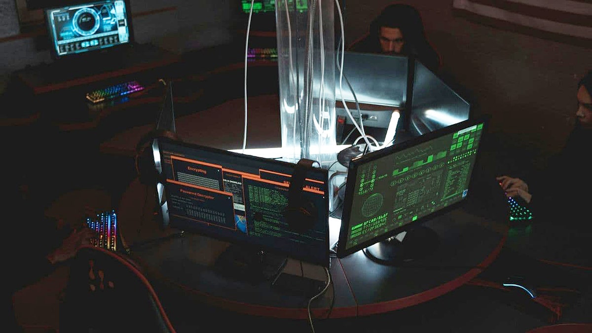 Computer monitors connected to wires display code.