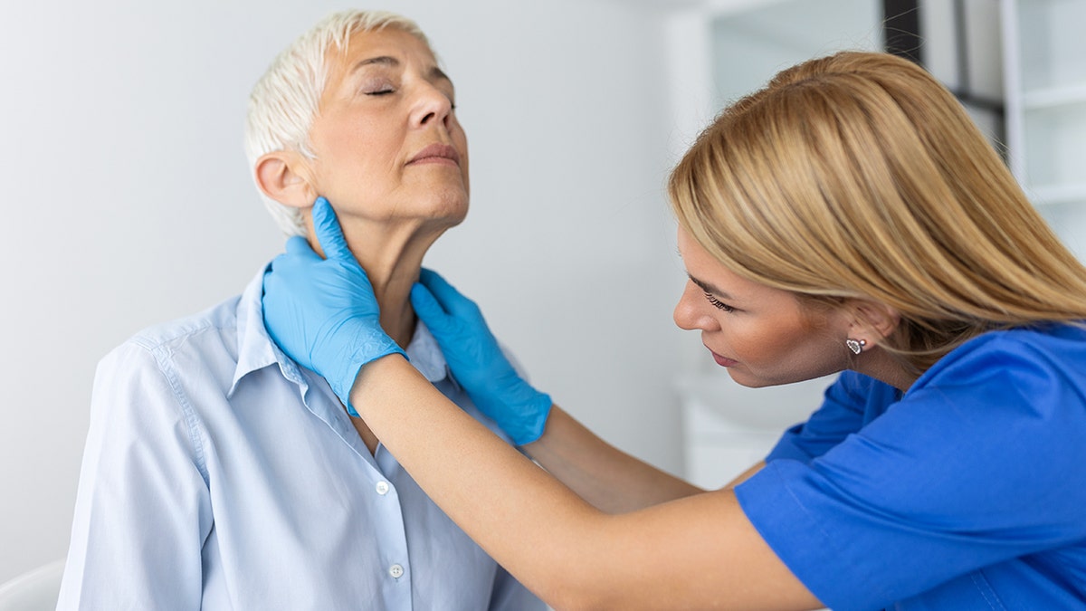 doctor examining throat of woman