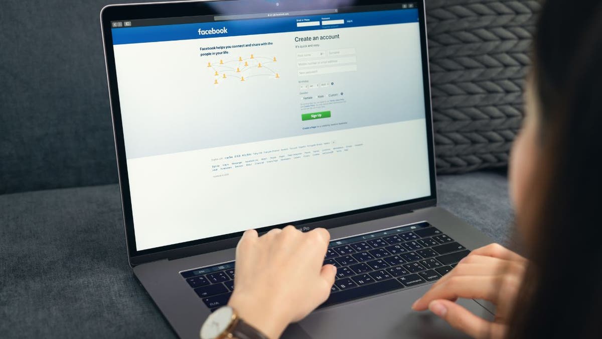 Woman using her laptop to log into Facebook