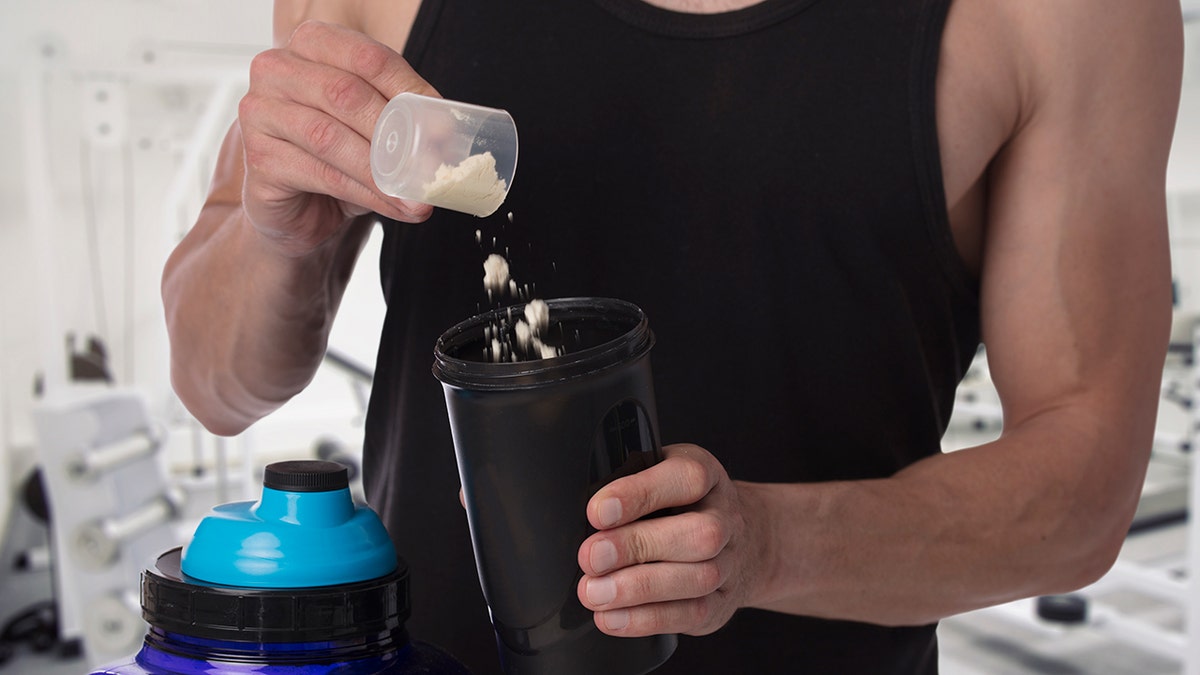 man scoops powder into cup