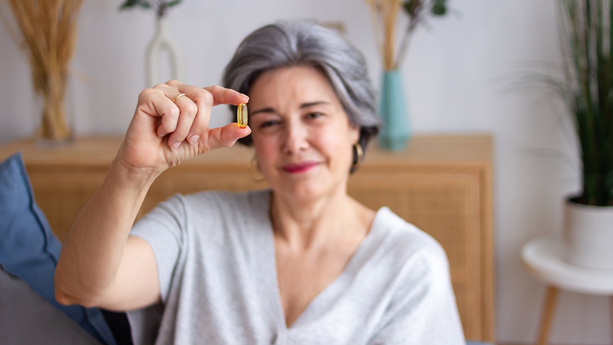 senior woman holding a vitamin