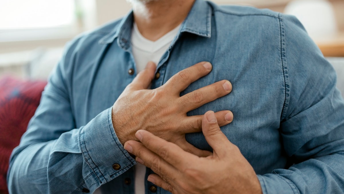 Man holding chest, heart pain