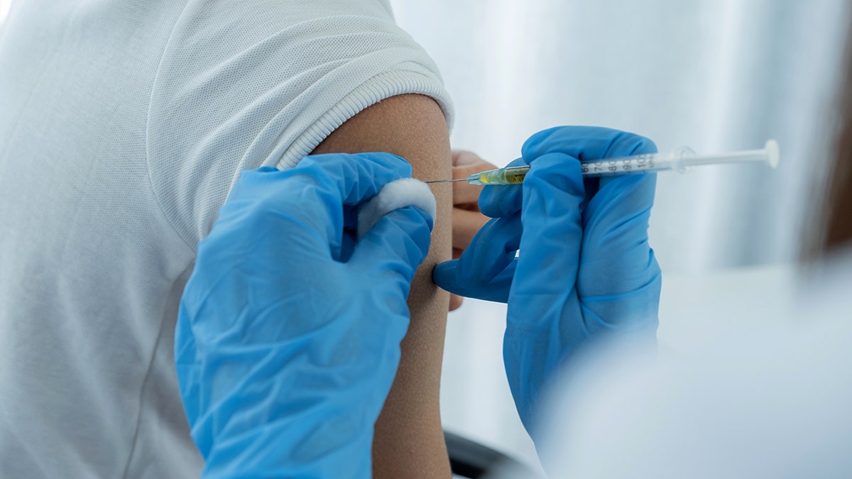 Person getting a flu shot closeup of needle