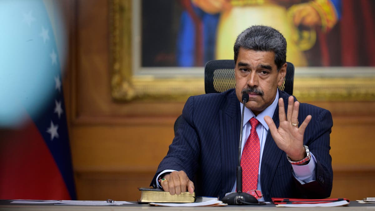 Nicolás Maduro with his hand raised.