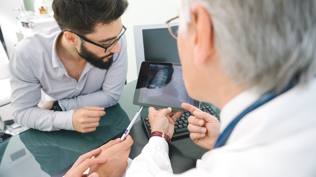 Mature doctor using a digital tablet for his diagnosis.