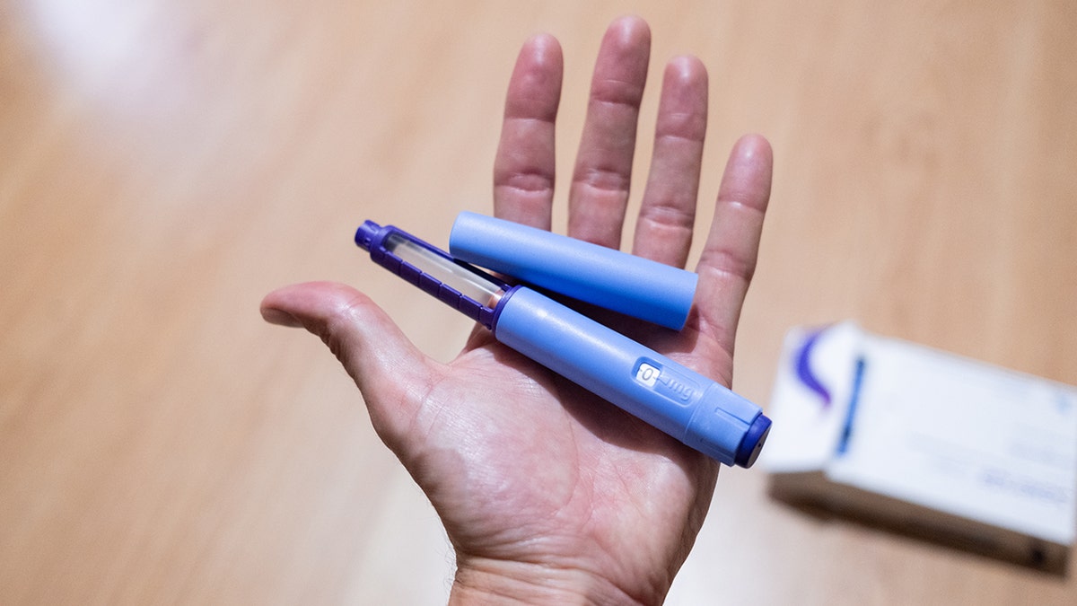 Hand holding GLP-1 injection pens