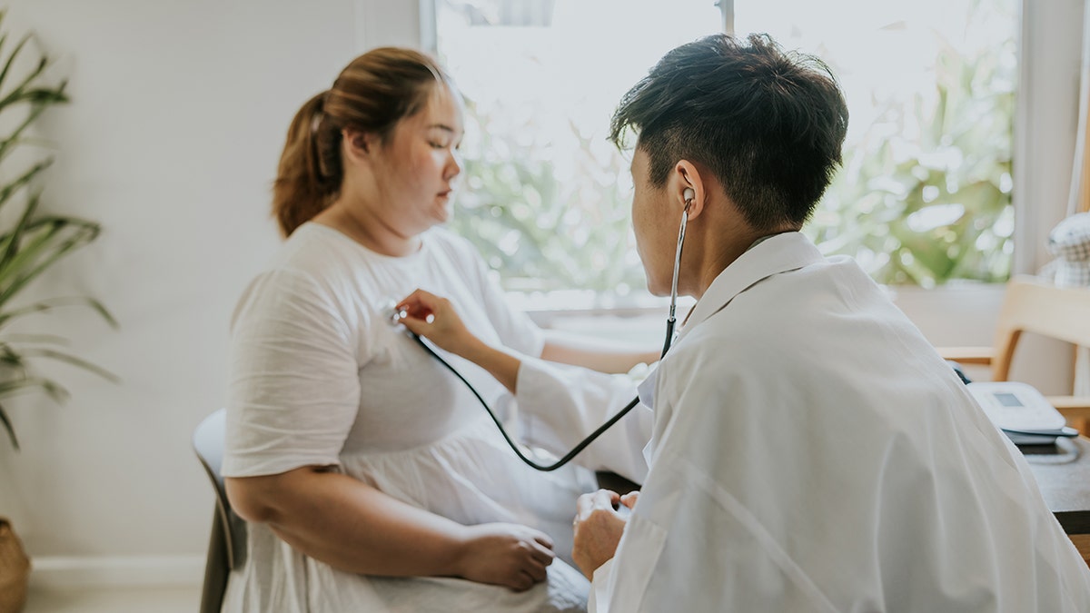 Doctor listening to patient's heartbeat