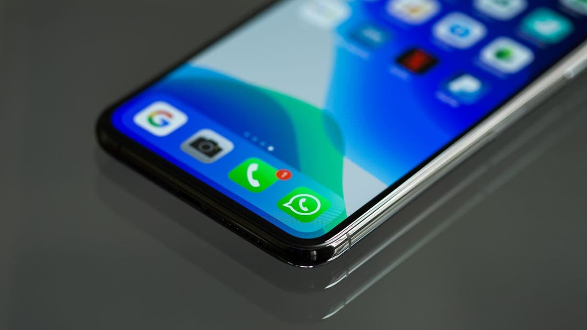 A low angle photos showing an iPhone screen with the phone and Whatsapp icons visible