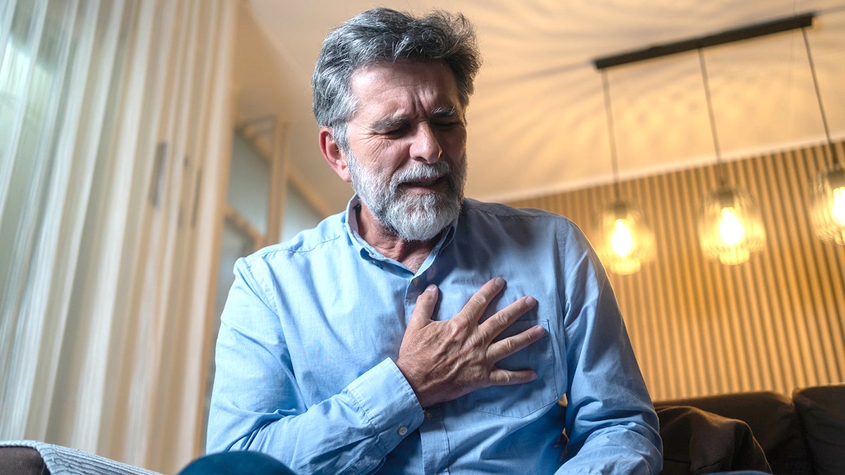 man in pain with hand over heart