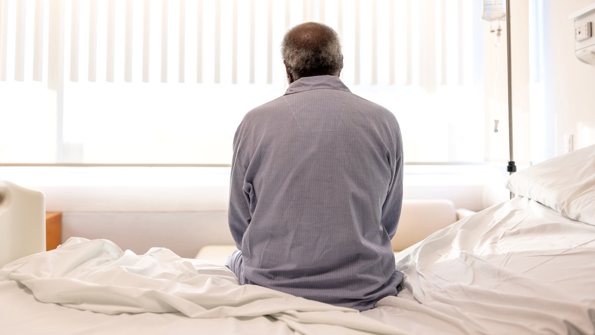 Man sitting on hospital bed - medical screenings
