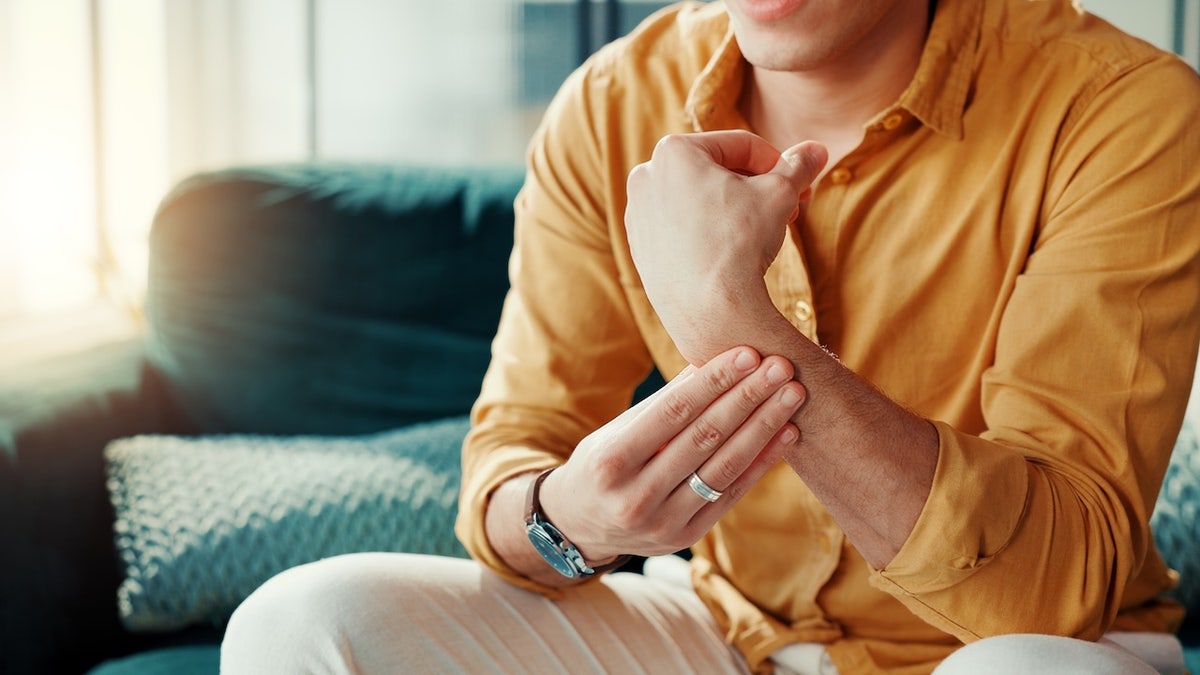 Young man holding his arm