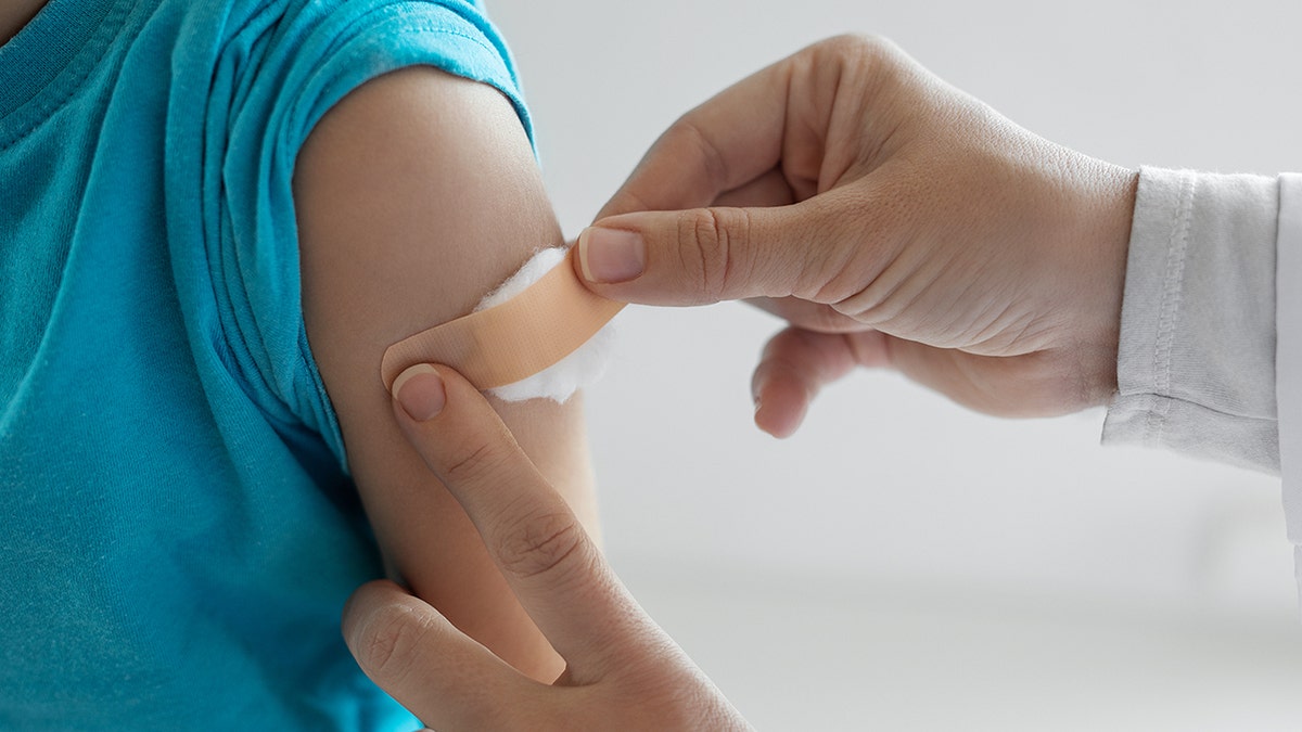 doctor putting a patch on shoulder after successful vaccination