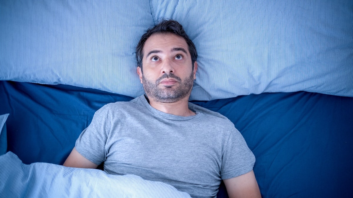 Man awake at night can't sleep