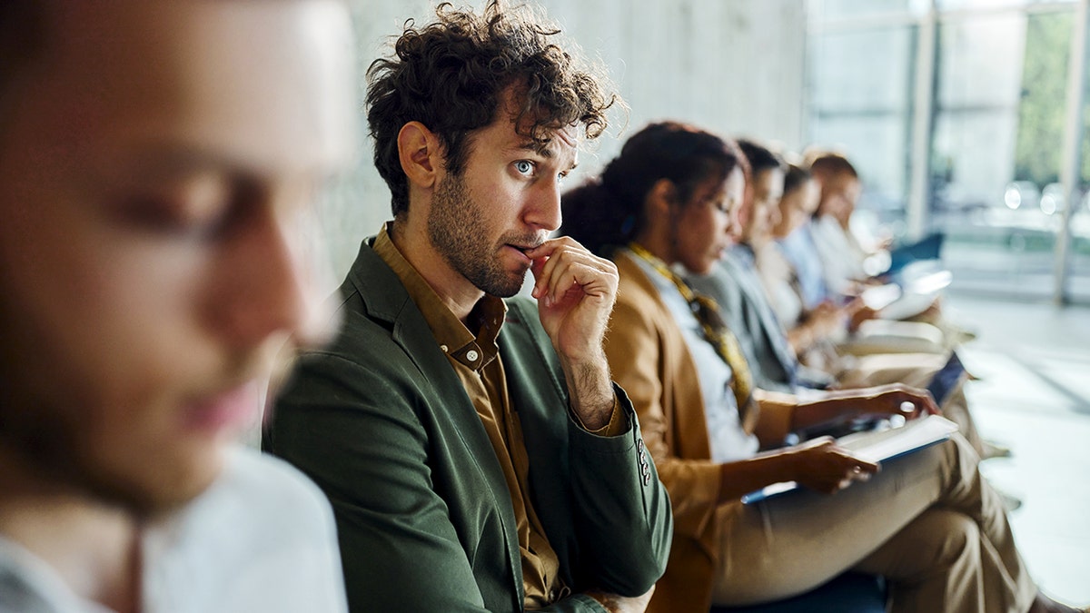 Worried businessman biting his nail while waiting for a job interview